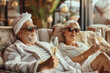 Relaxed senior couple in love enjoying serene moment among candles in spa with glasses of champagne