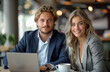© Raptecstudio - A man and a woman sharing a laptop and coffee at a table