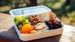Container with cookies, raisin, fruit, dried apricots, nuts. Street takeaway food container with a healthy meal. Segmented plastic container with beautiful healthy fresh food.