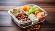 Container with vegetables, raisin, fruit, grapes, nuts. Street takeaway food container with a healthy meal. Segmented plastic container with beautiful healthy fresh food.