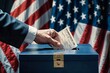 A hand in a suit places a ballot in ballot box against the background of the US flag