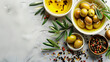Olive oil with olives and spices on a marble background.