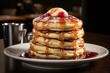 Stack of pancakes with strawberry jam and steaming coffee on rustic wooden table