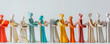 A diverse row of colorful sculptures depicting people of different backgrounds standing in unity, showcasing a spectrum of emotions and poses. Banner. Copy space
