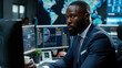 © sommersby - African American man is seated at a desk, focused on his computer screen as he works diligently