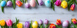Coloured eggs and coloured tulips on light grey wooden background. Easter style decoration banner. Holiday celebration greeting card. Copy space. Generative AI