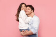 © Home-stock - My best daddy. Happy daughter embracing her father as man holds girl in arms, both smiling, posing over pink studio backdrop