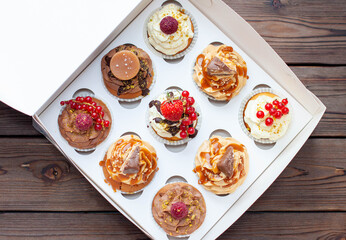 Wall Mural - Vanilla, chocolate and peanut butter cupcakes with salted caramel, fresh raspberry, strawbeery and red currant in gift paper box