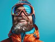 Smiling man with a beard in ski equipment on a blue background