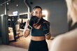 © Flamingo Images - Fit young woman wearing boxing gloves and a tank top practicing punches with a female partner during a self defence workout session together in a gym
