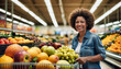 Beautiful middle-aged African American woman smiles while shopping at the supermarket with her cart in the fruit section.