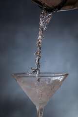 Canvas Print - Pouring chilled gin into a martini glass