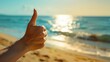 © Jane Kelly - Thumbs up sign. Woman's hand shows like gesture. Beach background
