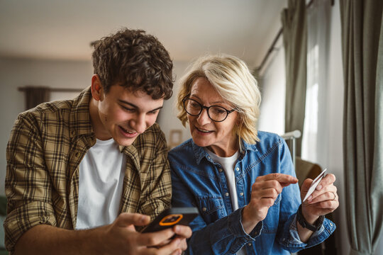 mother and son woman young man shopping online at home use credit card