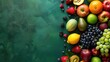 A colorful array of fresh fruits artistically arranged on a dark green surface