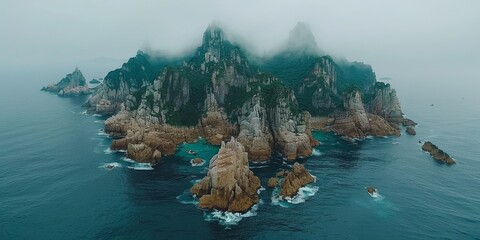 Canvas Print - Atmospheric islands shrouded in mist rising above the ocean, with jagged cliffs and turbulent waters