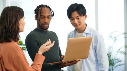 Poster - Multinational people talking while looking at laptop PC in the lobby. International business.