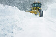大雪の道路を除雪する除雪車