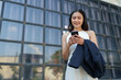 © crizzystudio - Confident and positive Asian online businesswoman using smartphone to relax with mobile application, use business chat and connect with customers outside online market place. Excellent profits.