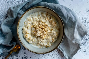 a healthy breakfast of overnight oats with milk in ceramic bowl - top view