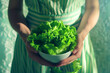 Girl housewife girl holding cup with fresh salad leaves in kitchen, preparing healthy light meal.