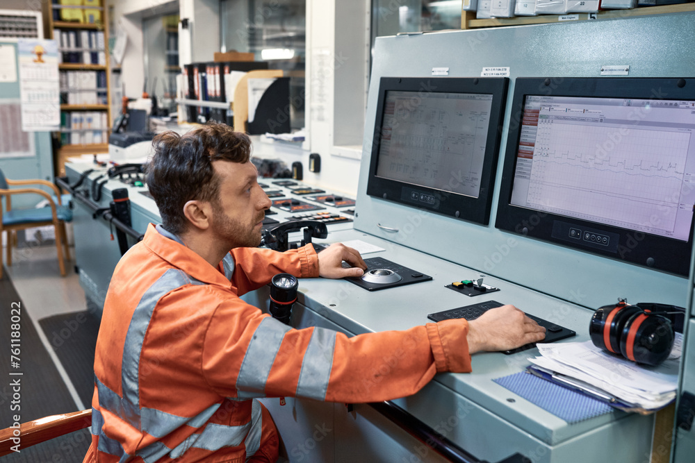 Engineer monitoring working parameters of equipment on the engine ...