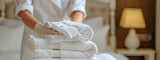 Fototapeta Sypialnia - the maid folds the towels. Selective focus.