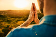 © baranq - Man praying in nature during sunset