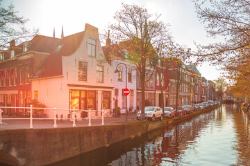 Wall Mural - Delft, Netherlands sunset street view with traditional dutch houses, bicycles, canal in downtown of popular Holland destination