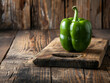 Green bell pepper on wooden cutting board. Food background.