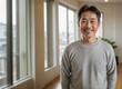 © Flux Forge - Photo of a happy middle-aged Japanese man in casual clothes relaxing inside a bright apartment