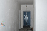 Fototapeta  - Prace wykończeniowe w nowym domu, zagruntowane ściany w korytarzu, wystająca elektryka w trakcie remontu