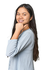 Wall Mural - Young chinese woman isolated points with thumb finger away, laughing and carefree.