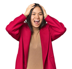 Wall Mural - Young chinese woman isolated screaming, very excited, passionate, satisfied with something.