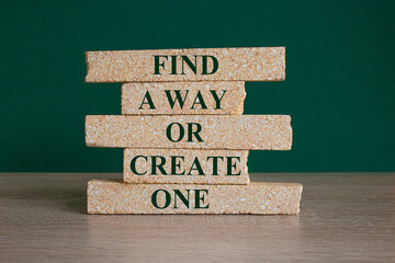 Find a way or create one symbol. Concept words Find a way or create one on brick blocks on a beautiful wooden table green background. Businessman hand. Business concept.