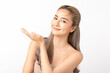 © Shutter B - A smiling young Asian woman presenting with an open hand against on white background., ideal for product placement. Skincare and health wellness, Facial treatment, Perfect skin, Natural makeup.
