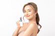 © Shutter B - Attractive young Asian woman holding a cosmetic spray bottle, smiling on white background. Clean fresh bare skin concept. Facial treatment, Perfect skin, Natural make up.