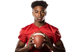 Fototapeta Konie - A young African American man athlete in a red jersey, confidently holding a football, isolated on a white background