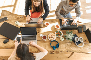 Team of programmers coding on laptops working at creative office