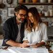 © Bussakon - Engaged Couple Designing Wedding Stationery on Home Office Desk