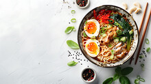 Ramen Bowl With Soft-boiled Eggs, Noodles, Chicken, Red Peppers, Pak Choi, And Green Onions, Garnished With Sesame Seeds And Basil. Overhead Shot On A White Textured Background. Traditional Japanese C