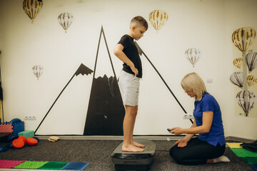 Female psychologist working with little boy at home