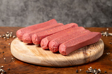 Wall Mural - Raw sausage. Butcher products. Sausages made from uncooked beef on a dark background