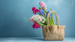 beautiful straw bag with seasonal flowers of hyacinth and carnation blossom , copy space for text