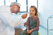 © Halfpoint - Doctor examining little girl's ear using otoscope, looking for ear infection. Friendly relationship between the doctor and the child patient.