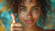 Close up portrait of a beautiful curly girl or young woman showing thumb up