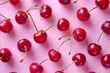 Ripe red cherries with water drops on pink background, top view summer fruit concept