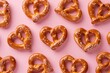 Heartshaped arrangement of pretzels on pink background for Valentine's Day concept