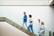 © Halfpoint - Portrait of team of doctors standing on stairs. Healthcare team with doctors, nurses, professionals in medical uniforms in hospital.