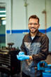 © bnenin - A portrait of a smiling mechanic posing for the camera while working in his garage.